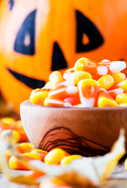 istock Halloween festive composition with sweet corn in bowl and smiling pumpkins guards 1053648050