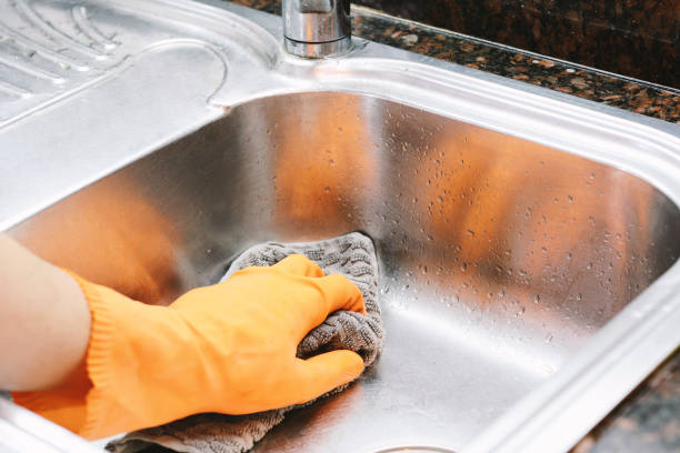 istock Hands in rubber gloves washing dishes with spon 1053648294