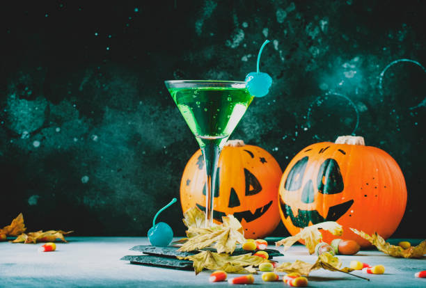 istock Halloween composition with festive drink, green cocktail and pumpkins lanterns 1053648418