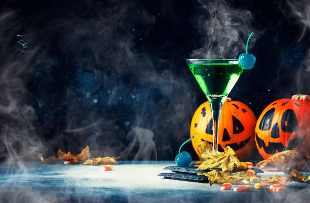 halloween-komposition mit festlichen getränk, grüne cocktail und kürbissen laternen - glass autumn halloween food stock-fotos und bilder