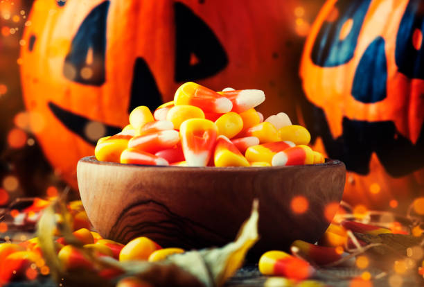 istock Halloween festive composition with sweet corn in bowl and smiling pumpkins guards 1053650472