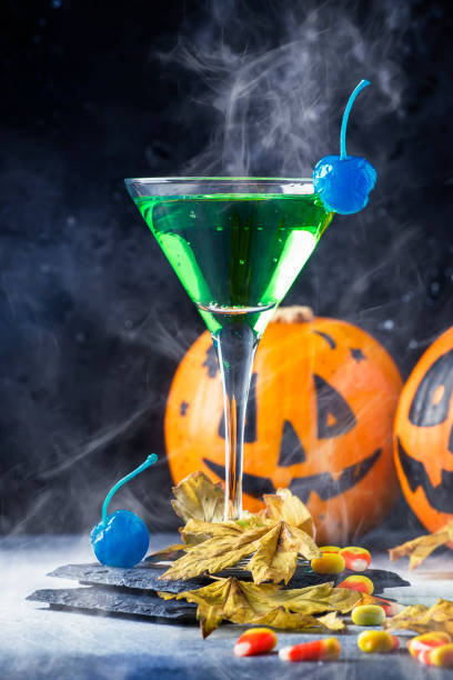 istock Halloween composition with festive drink, green cocktail and pumpkins lanterns 1053650498