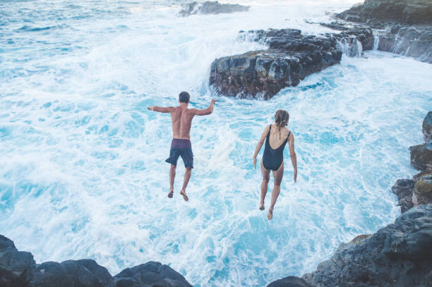 istock A millennial-age couple leaping into the ocean 1053658700