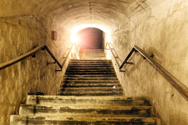istock Corridor of old abandoned underground Soviet military bunker. Staircase goes up to surface 1053692300