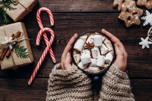 woman in knitted sweater with mug of hot chocolate Warming concept. Woman hands in knitted sweater with mug of hot chocolate. Coziness, home, winter holidays celebration hot chocolate photos stock pictures, royalty-free photos & images