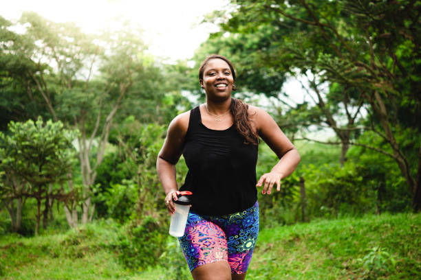 corpo donna positiva che si esercita in natura - running jogging african descent nature foto e immagini stock