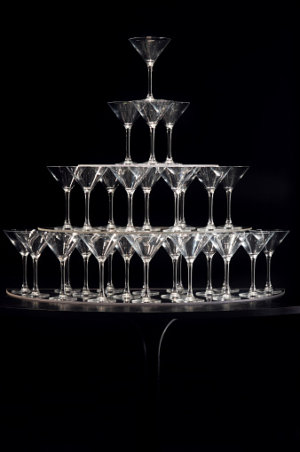 tower of empty champagne glasses on a black background