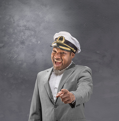 Boat captain in suit pointing and smiling at you