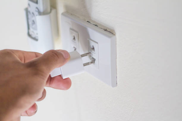 istock Hand plugging in appliance to electrical outlet in wall. 1053722076