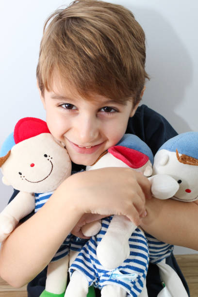 istock Little boy holding three cute boy cloth doll 1053724192
