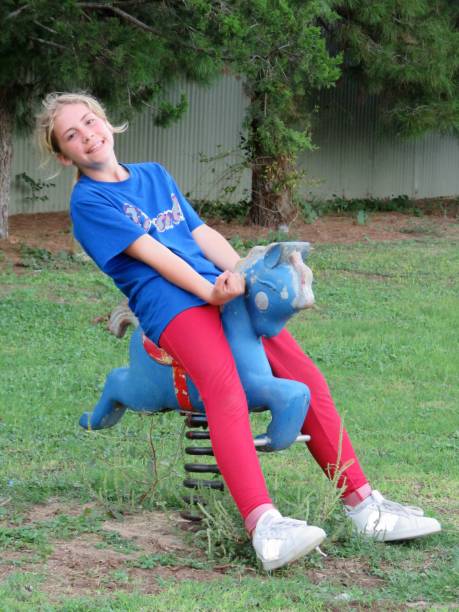 istock girl playing on playground equipment 1053728800