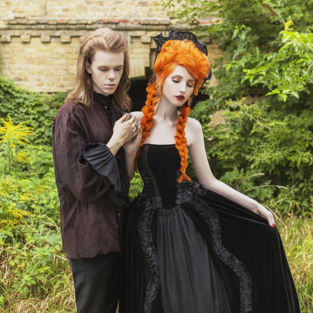 Pareja Gótica En Un Disfraz De Halloween Pálidos Vampiros Nomuertos En Ropa Victoriana Oscura Mujer Pelirroja Con Vestido De Carnaval Negro Ropa Gótica Para Fiesta De Halloween Par De Muertos Vivientes En Pareja Gótica En Un Disfraz De Halloween Pálidos Vampiros Nomuertos En Ropa Victoriana Oscura Mujer Pelirroja Con Vestido De Carnaval Negro Ropa Gótica Para Fiesta De Halloween Par De Muertos Vivientes En