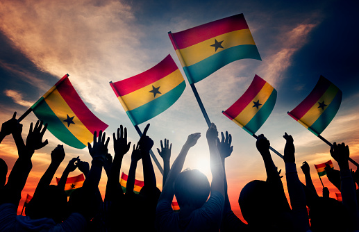Silhouettes of People Holding Flag of Ghana