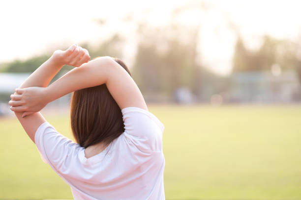 istock Young woman stretching her arms before running on track. Healthy and exercise concept 1053745954