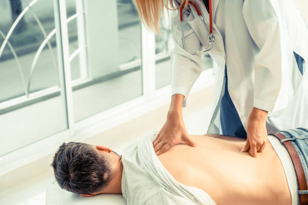 woman doctor and male patient in hospital office - physical injury backache occupation office imagens e fotografias de stock