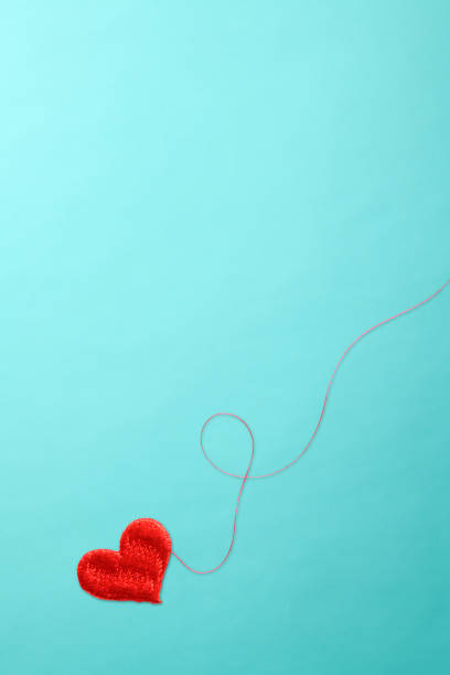 istock One red heart shape embroidery with red thread on blue background. 1053753244