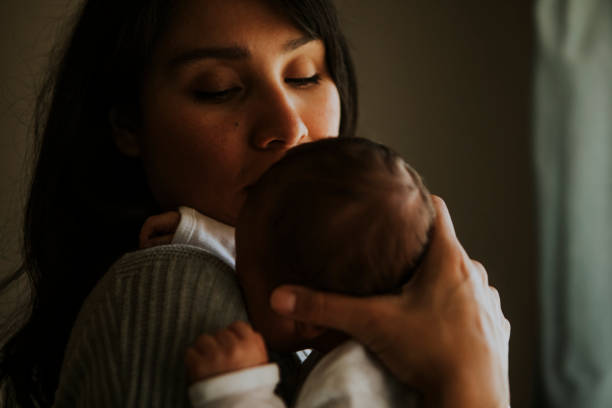 istock Mother holding her baby indoors 1053755822