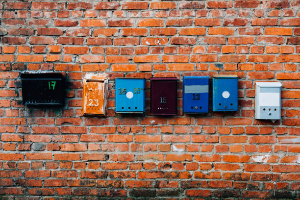 istock Mailboxes of different colors on a brick wall 1053758434