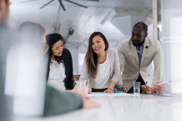 istock Two ethnic businesspeople signing contracts at a conference table 1053759288
