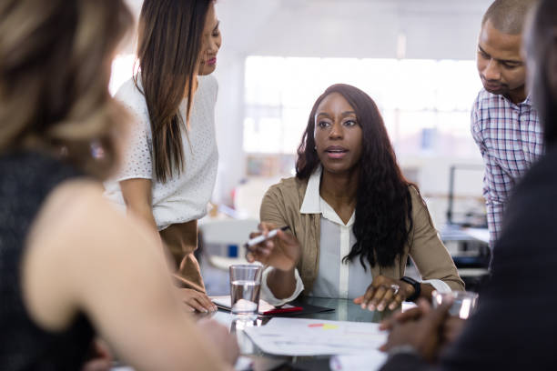 istock Female CEO leads a team meeting at the conference table 1053759318