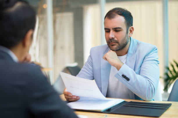 istock Pensive Hispanic businessman reading contract 1053761626