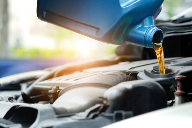 refueling and pouring oil quality into the engine motor car transmission and maintenance gear .energy fuel concept. - motor oil bottle imagens e fotografias de stock