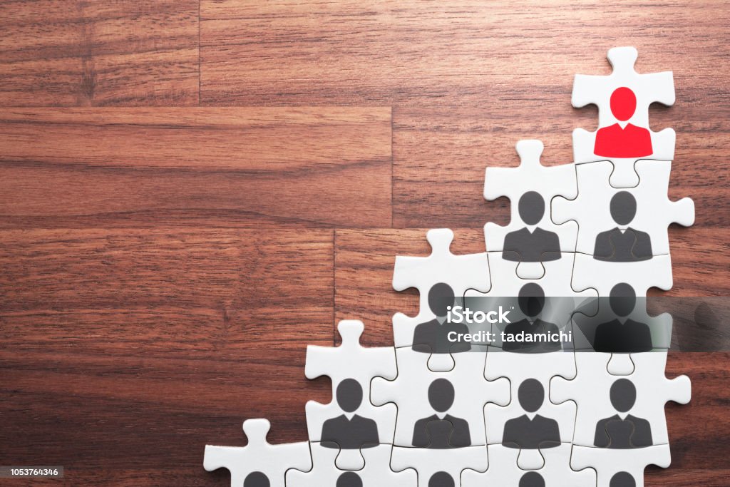 Career development and promotion concept. Going and standing on height. Personal growth and development. Assembling jigsaw puzzle pieces on wood desk. Ladder of Success Stock Photo