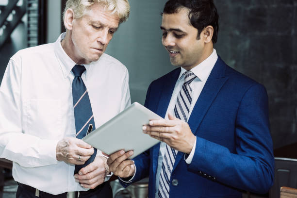 istock Two Businessmen Reviewing Presentation on Tablet 1053764394