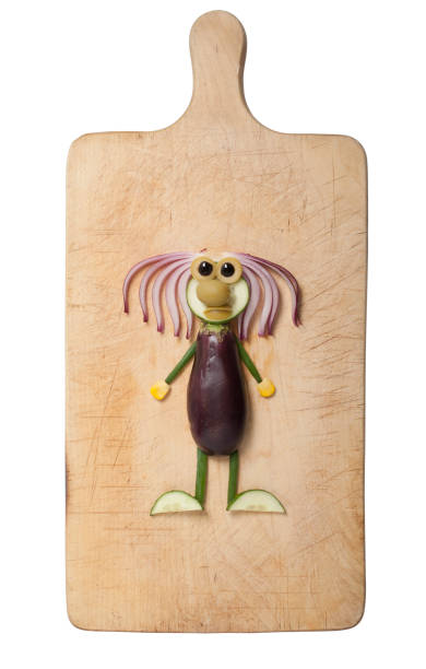 Creative idea of making a man from eggplant, onion, cucumber, olive and corn. Shot on cutting board and isolated background.