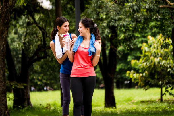 istock Attractive young women taking a break after exercise in a park 1053768658