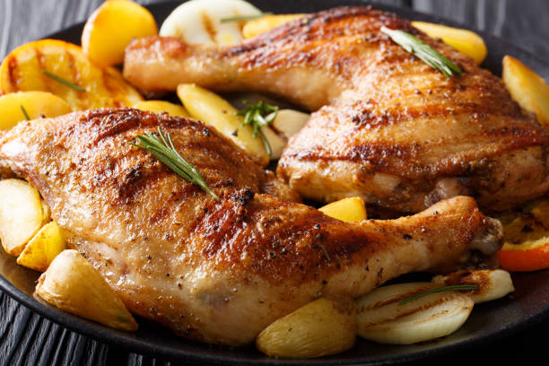 istock grilled chicken leg with oranges, onions and potatoes macro. horizontal 1053773790