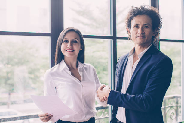 istock Smiling business people shaking hands 1053774014