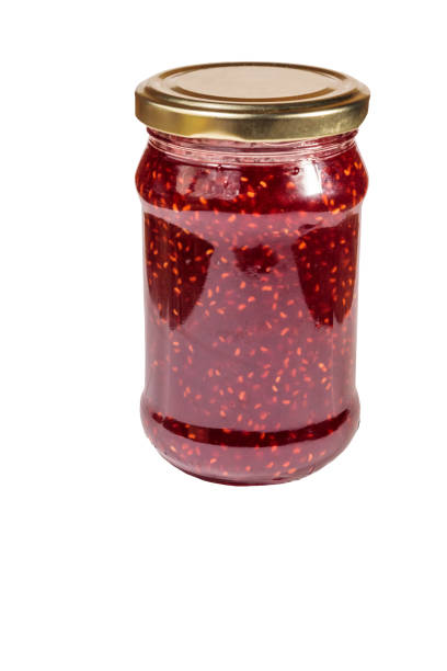 istock Raspberry jam in glass jar isolated on white background 1053774234