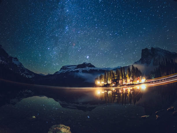 istock Emerald lake with illuminated cottage under milky way 1053777492