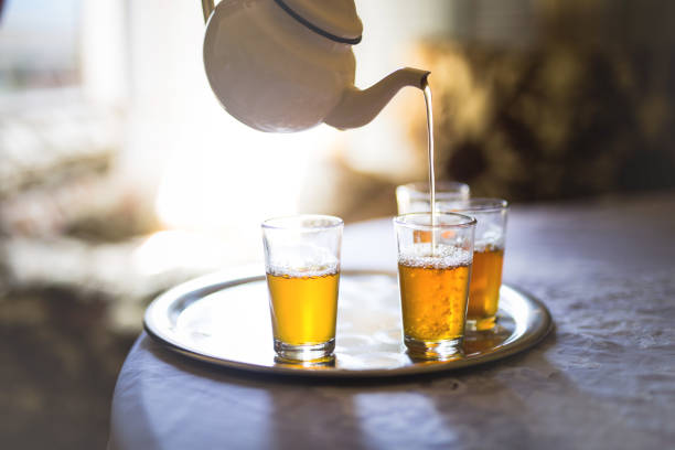 istock Pot Pouring Tea In Glass On Table 1053779022