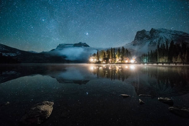 istock Emerald lake with illuminated cottage under milky way 1053779792