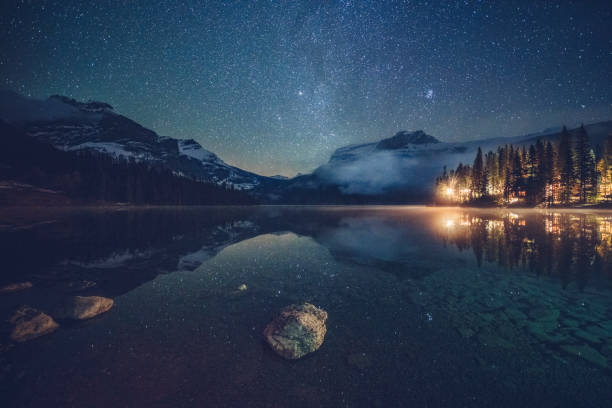 istock Emerald lake with illuminated cottage under milky way 1053779994