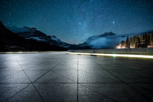 istock empty parking lot front of snow-capped mountain under star sky 1053780036