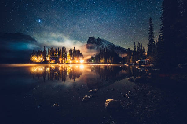 istock Emerald lake with illuminated cottage under milky way 1053780180