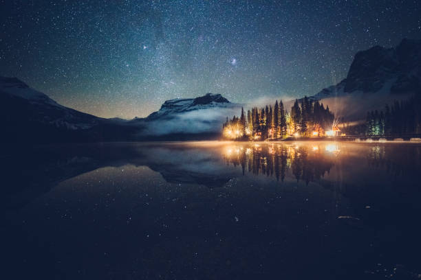 istock Emerald lake with illuminated cottage under milky way 1053780226