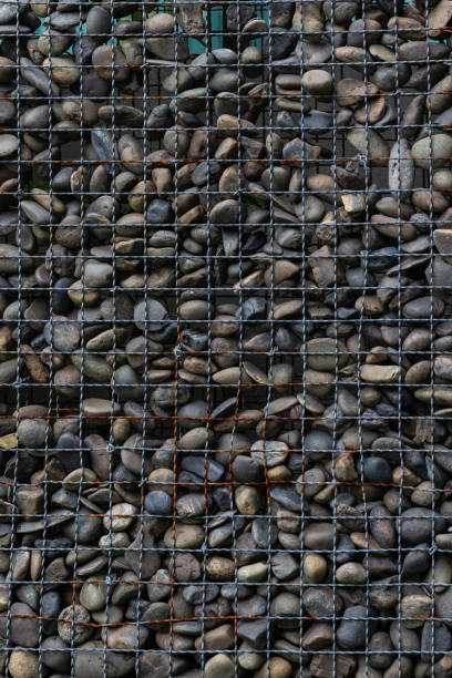 istock Old rusty metal grate filled with stones. 1053783398
