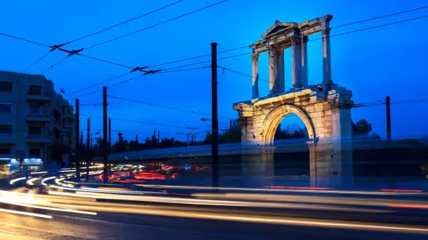 Greece, Athens. Car traffic in front of the Arch of Hadrian in the evening