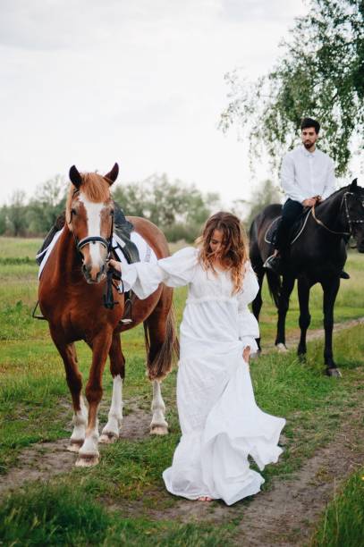 istock Couple Riding Horse On Field 1053791530