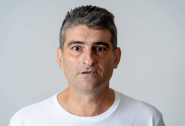 istock Portrait of a 40s 50s man in shock with a scared expression on his face making frightened gestures in human emotions feelings and facial expression concept isolated on grey background. 1053796142