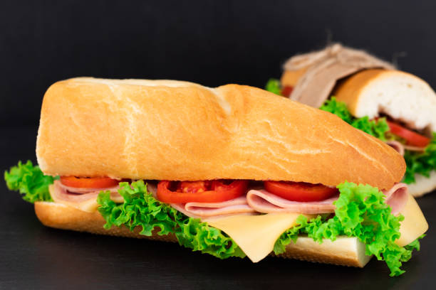 istock Big sandwich with meat and cheese on dark background 1053800448