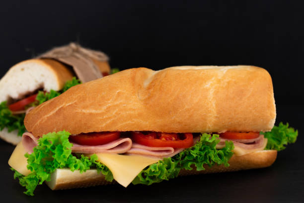 istock Big sandwich with meat and cheese on dark background 1053800480