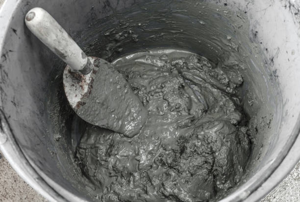 istock Trowel and cement mortar in mixing bucket for construction building. 1053803130