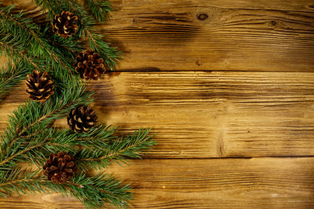 istock Christmas composition with fir tree branches and cones on wooden background. Top view, copy space 1053807086