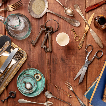A top shot of many vintage objects, flea market stuff on a wooden table, a vintage background with a place for text