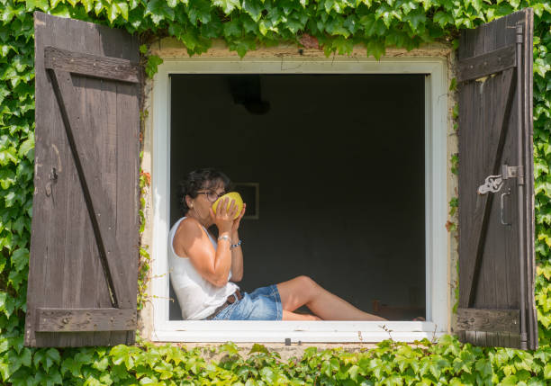 Woman in front of home holding mask
